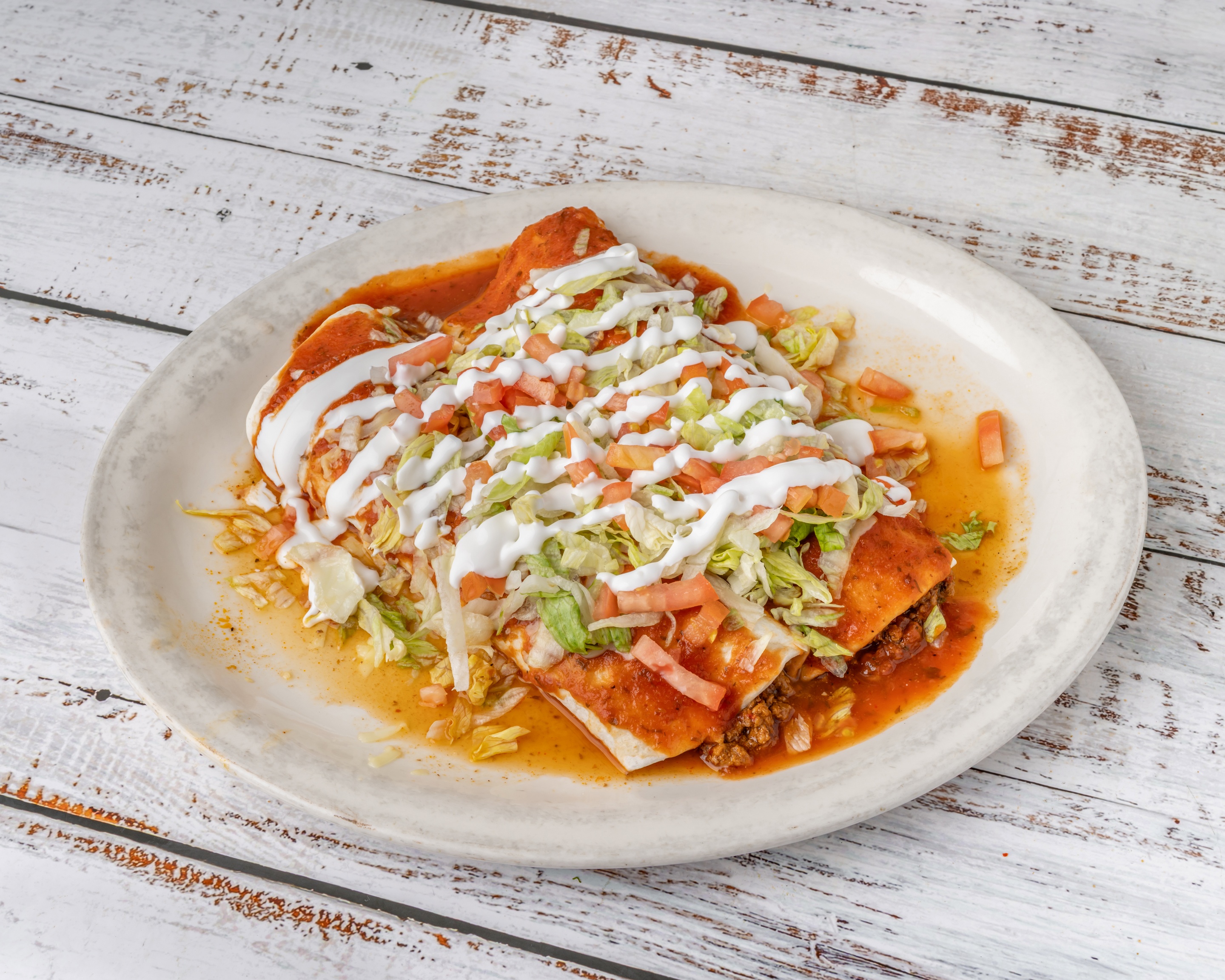 Burrito Deluxe smothered in red and white sauce