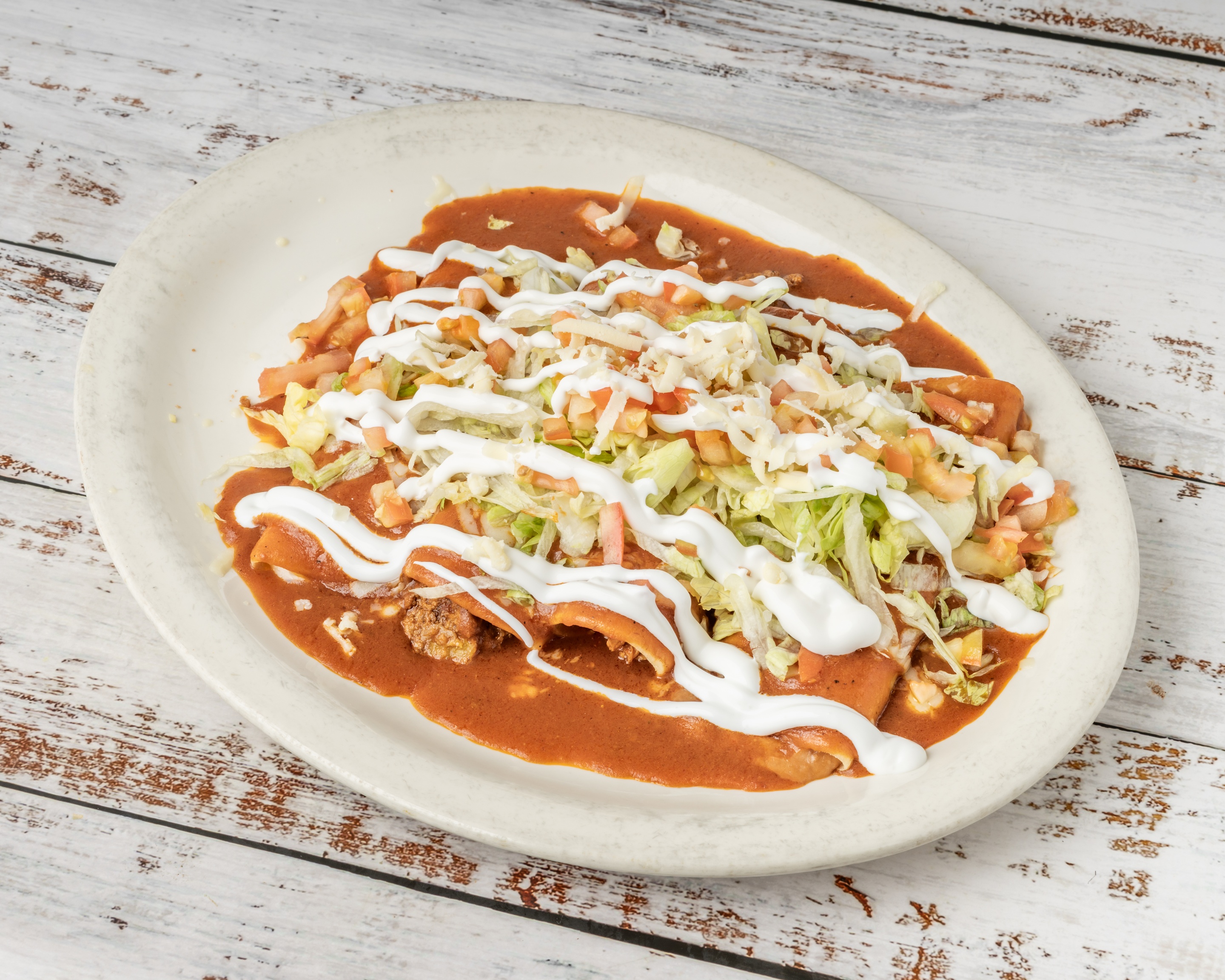 Enchiladas Supreme with lettuce and sour cream